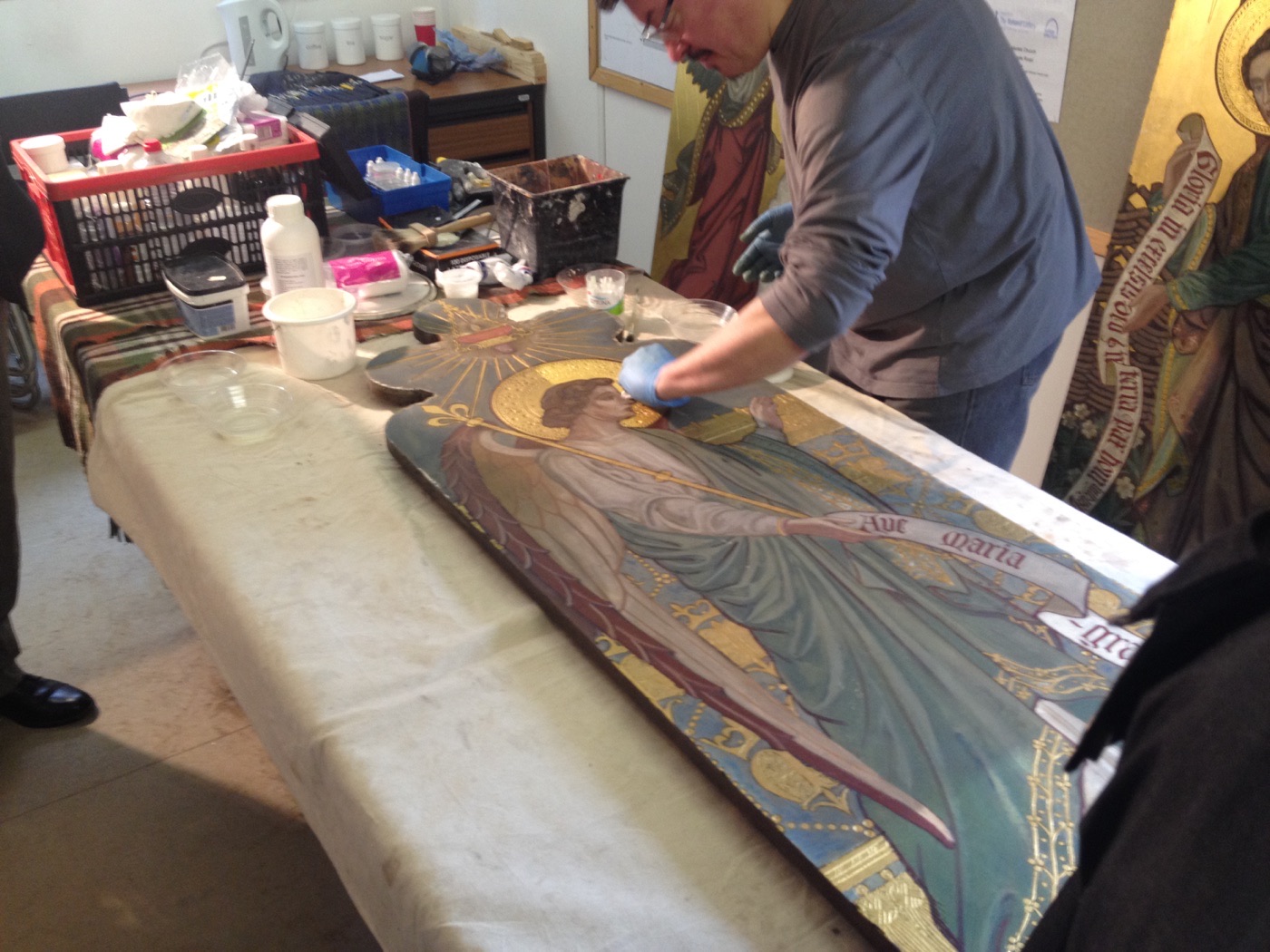 Silvano Cioci-Faux cleaning the Gabriel reredos panel with a cotton swab