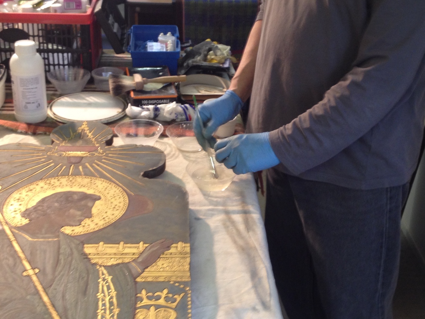 Silvano Cioci-Faux preparing a conservation cleaning solution beside the reredos panel