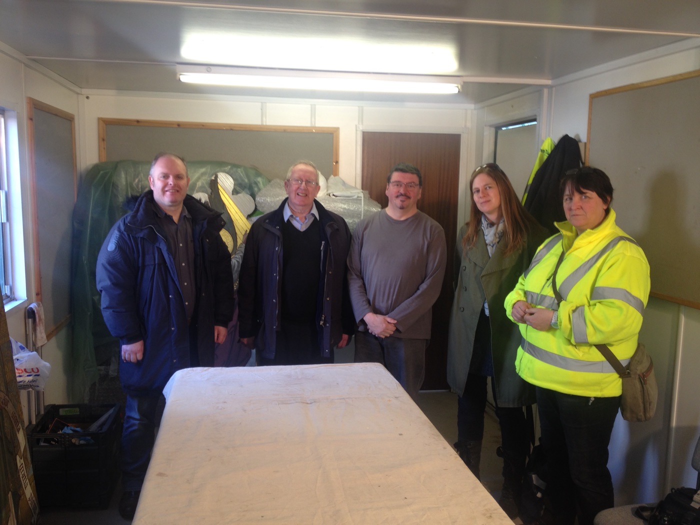 Silvano Cioci-Faux with workshop attendees standing behind the table in the site office