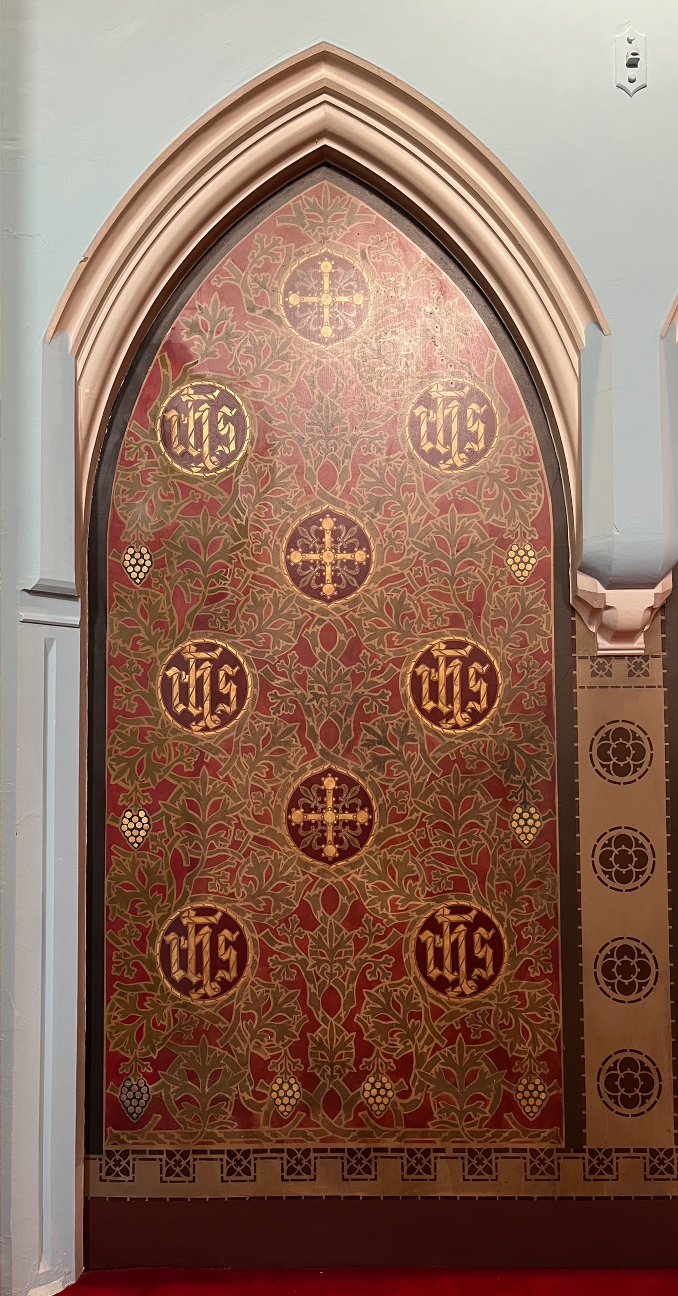 Same arch after lime plaster repair and stencil reinstatement at St Francis de Sales Church, Walton